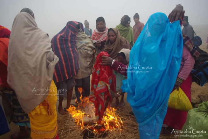 Devotees drying clothes over fire after holy bath at Kenduli