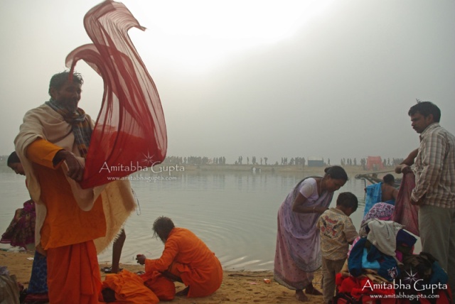 A devotee dries his clothes after the holy bath