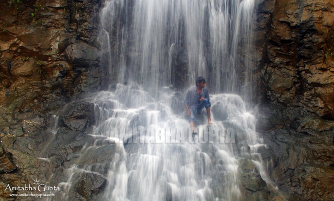 A local resident taking a bath at one of the many waterfalls at Tamhini Ghat
